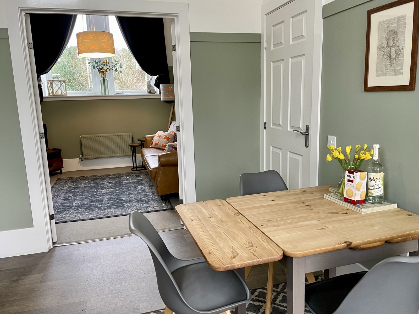 Dining table for four with daffodils, looking through to the living room