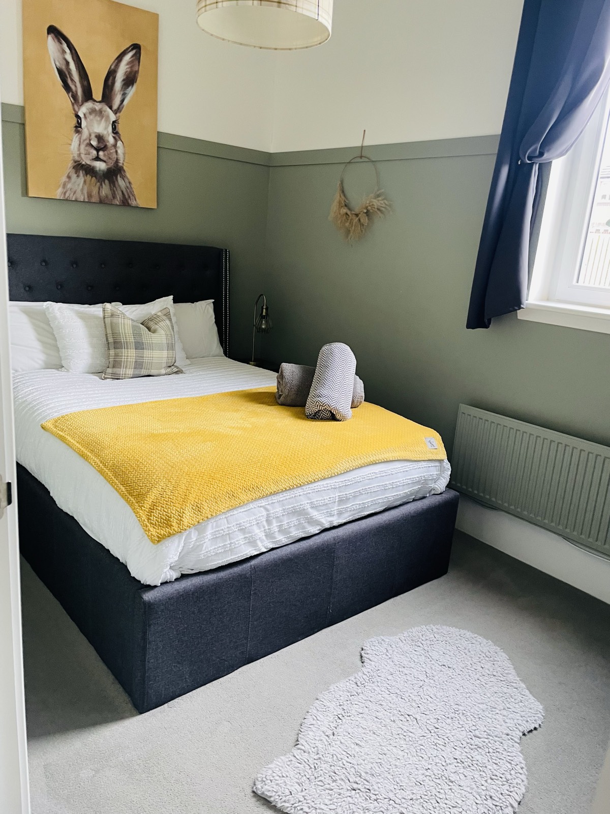 King-size bedroom with hare painting and yellow throw