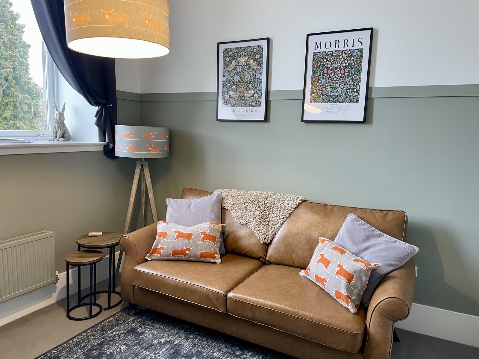 Living room with tan leather sofa and William Morris prints at The Old Schoolhouse, Kinross