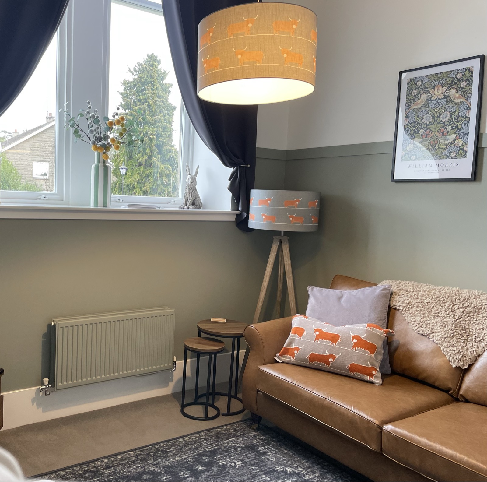 Living room window corner with Highland cow lampshade and tripod lamp